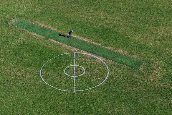 A man inspects the synthetic cricket pitch at Lalor Reserve.