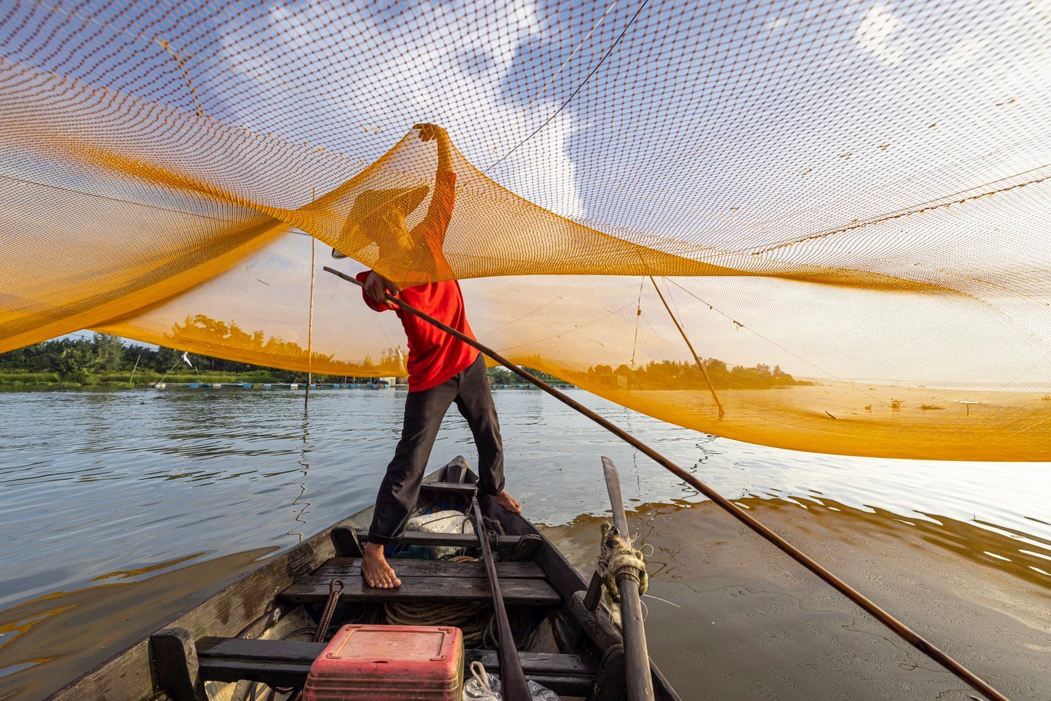 a fisherman holds a net