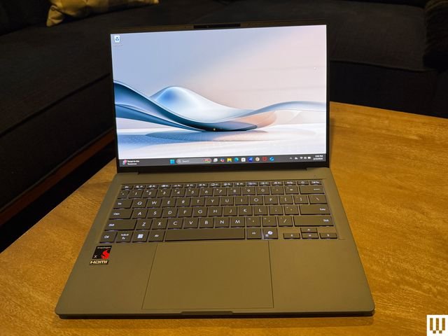 Front view of open Asus Zenbook A14 laptop with screen showing abstract art