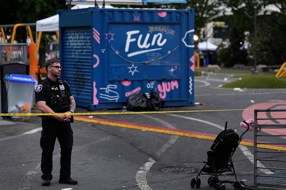 A police officer stands in a closed area after the shooting.