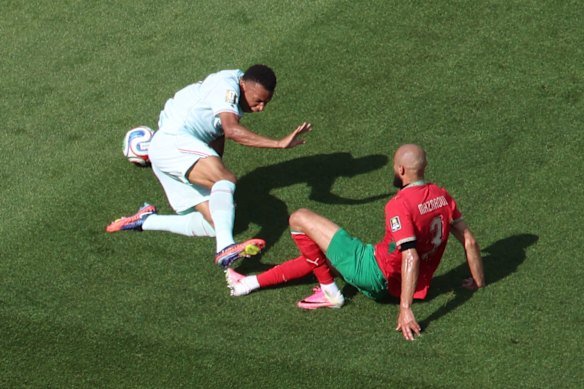 Noussair Mazraoui, from Morocco, commits a penalty while tackling Kylian Mbappé.