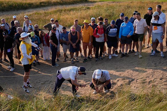 Lucas Herbert and a rules official observe the lie of his ball on the 17th hole. 