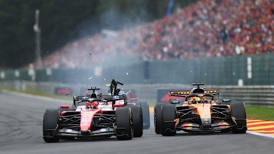 Debris flies after Charles Leclerc's Ferrari makes contact with Oscar Piastri's McLaren.