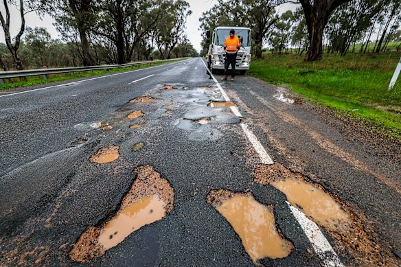 Tow truck driver Chris Welsh next to potholes on the A300 between Benalla and Mansfield.