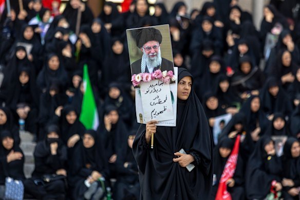 A woman holds a sign as people gather at Imam Khomeini's Grand Mosalla for a farewell ceremony for the late Ayatollah Ali Khamenei of Iran.