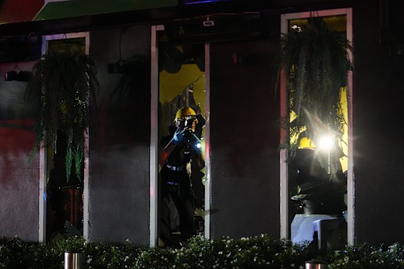 Forensic police officers inspect the scene of the fire.