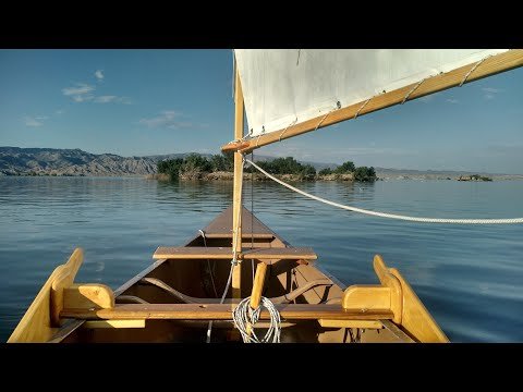 A man turns a canoe into a sailboat and tests it
