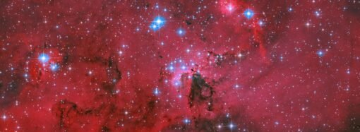 NASA’s Hubble captures a crimson cloud glowing with white and blue stars
