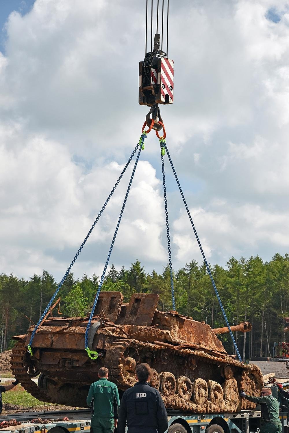 The StuG III is lifted from the excavation ground using a crane winch