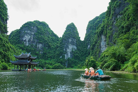 Paddling towards a temple among limestone karsts in Trang An.