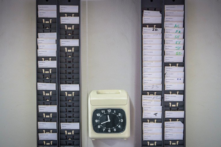 A wall-mounted time recording machine for employees to clock in with time cards.