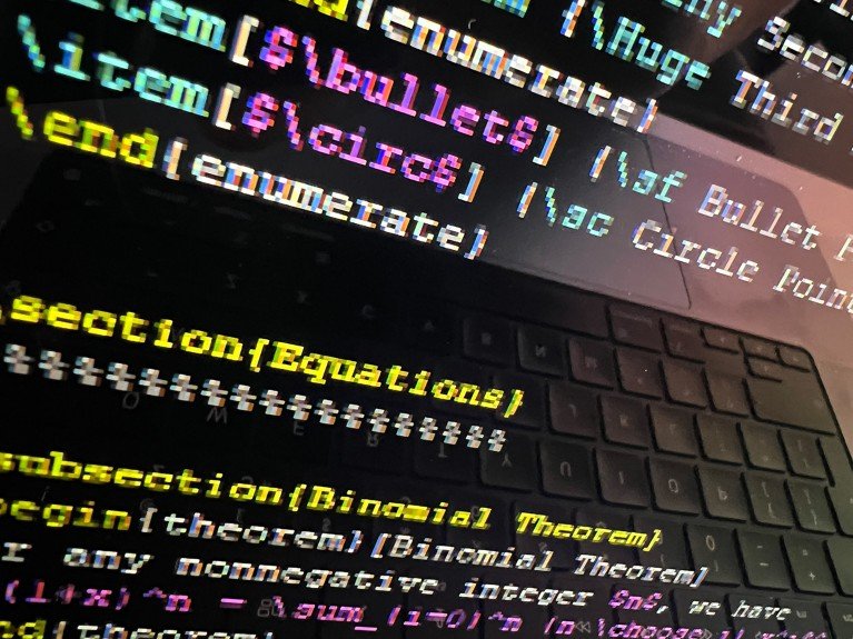 A close-up view of a colorful LaTeX code on a black background with a reflection of a computer keyboard.