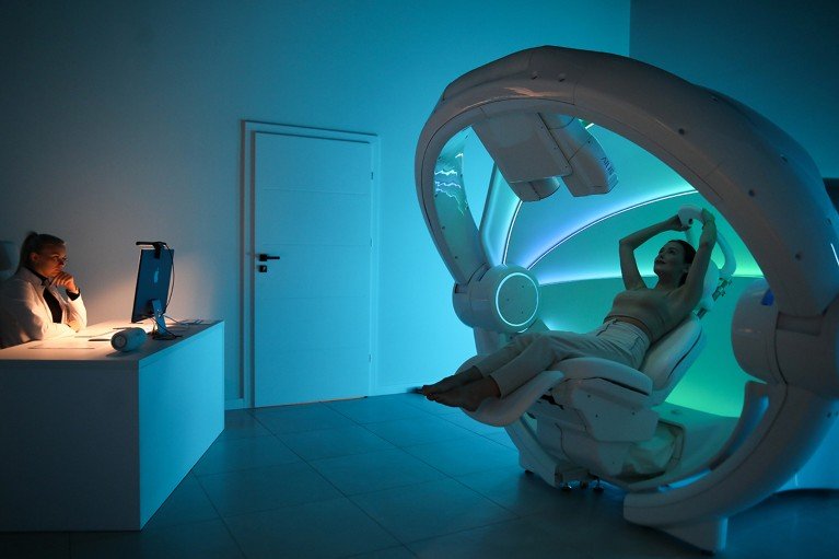 A woman undergoes an AI-assisted breast cancer scan while a medical professional monitors the test on a computer.