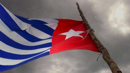 A Papaun holds the Morning Star independence flag.