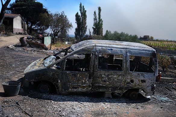 A burnt vehicle lies in front of a charred house in Navas del Rey, west of Madrid.