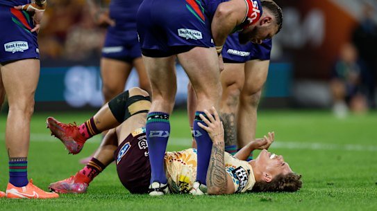 Reece Walsh lies injured during the round 24 match between the Broncos and the Warriors.