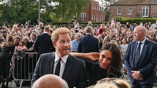 Prince Harry and Meghan, Duchess of Sussex meet people after viewing the floral tributes for the late Queen Elizabeth II outside Windsor Castle, in 2022. 