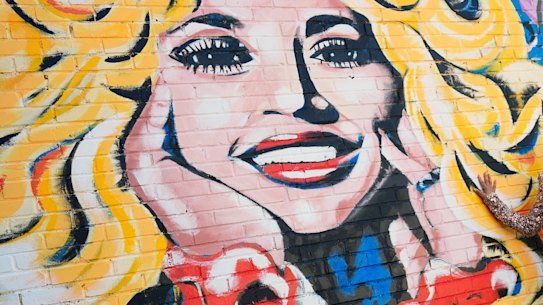 Singer Sunny Holiday poses for a photo near a mural of Dolly Parton in Nashville.