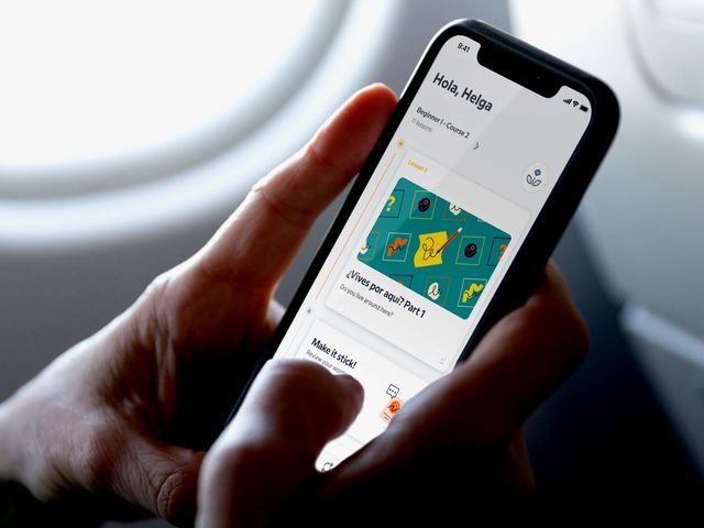 Close-up of a person's hands holding a smartphone that is displaying the Babbel app
