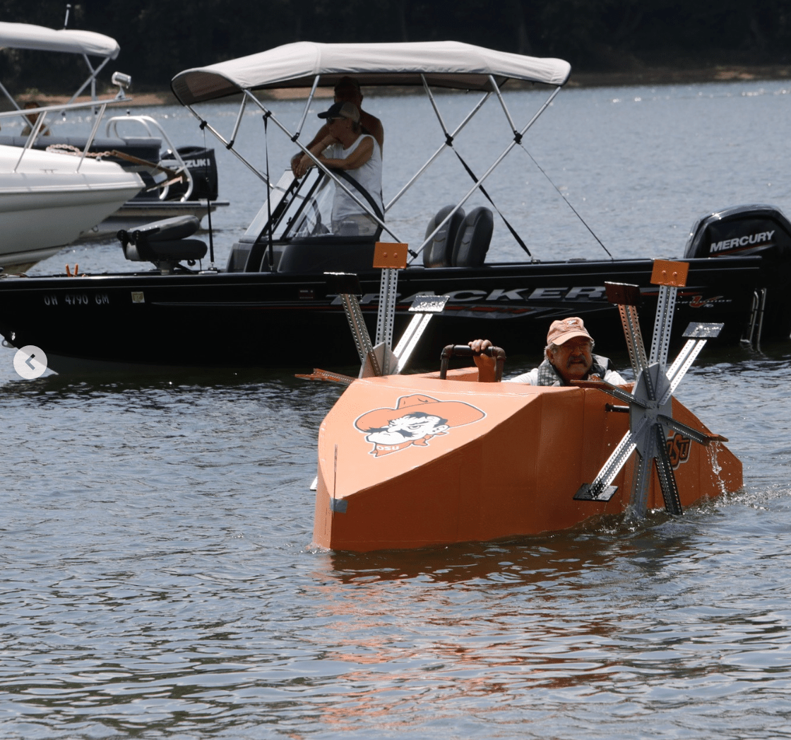 Man in cardboard boat with metal propellers