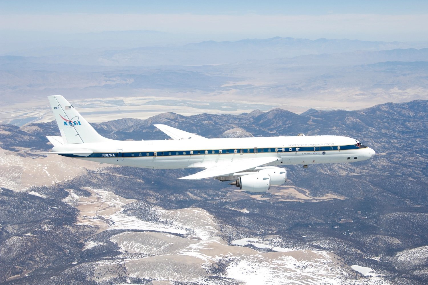 NASA DC-8 jet flying over snowy hills