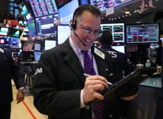 Dow surges to record close after fresh tech rally and a plunge in oil prices