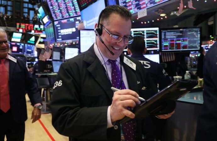 Dow surges to record close after fresh tech rally and a plunge in oil prices