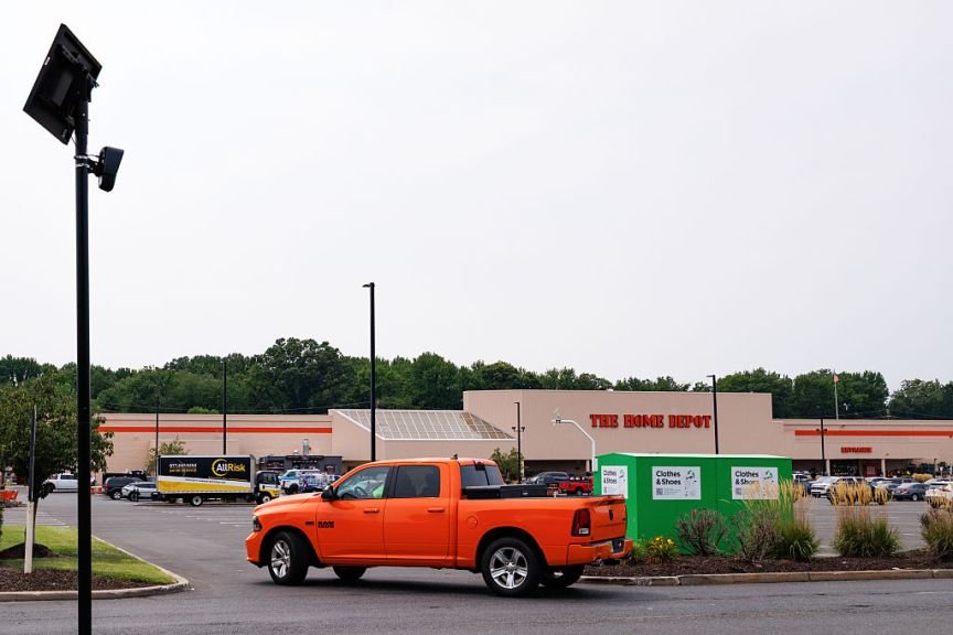 A Flock camera beside a Home Depot parking lot.