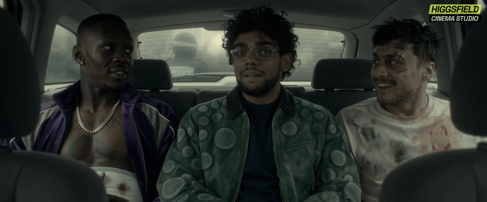 An image of three men sitting in the back of a car smiling at each other.