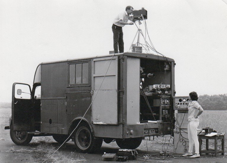 Black and white archive photo from the 1970s, showing two members of the RAE infrared group operating the trials vehicle in the field, 1970s.