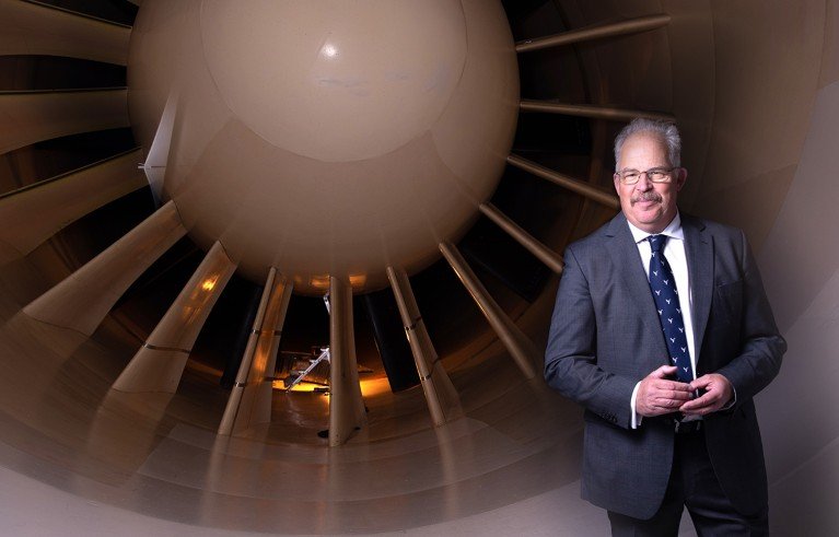 Portrait of David Dunford with the turbine of a plane behind him.