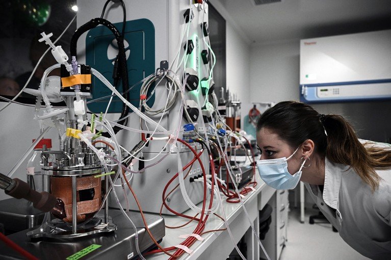 A laboratory technician conducts cell therapy research at a biotechnology company developing treatments for Parkinson’s disease.
