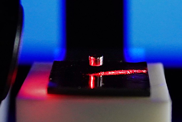 A microscopic permanent magnet levitates above a diamagnetic graphite stabilizer while being probed by a laser beam.