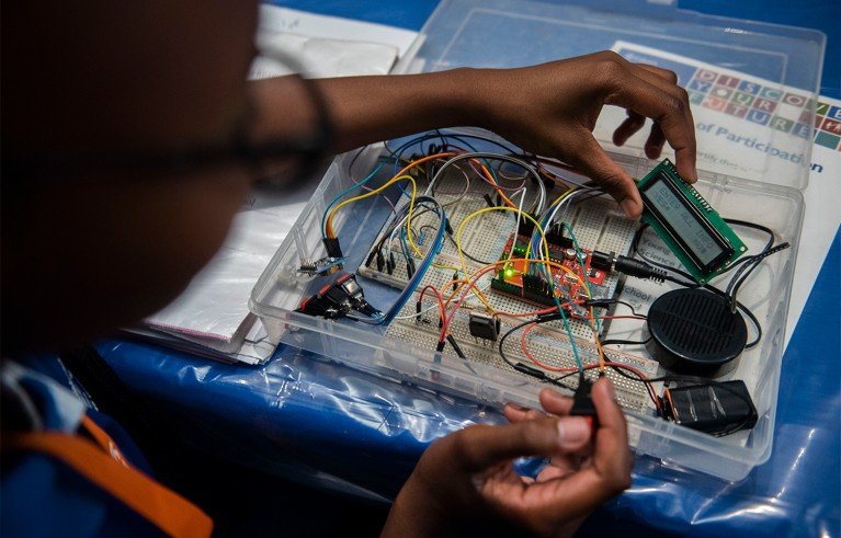 A person working on an electronics project at a table.