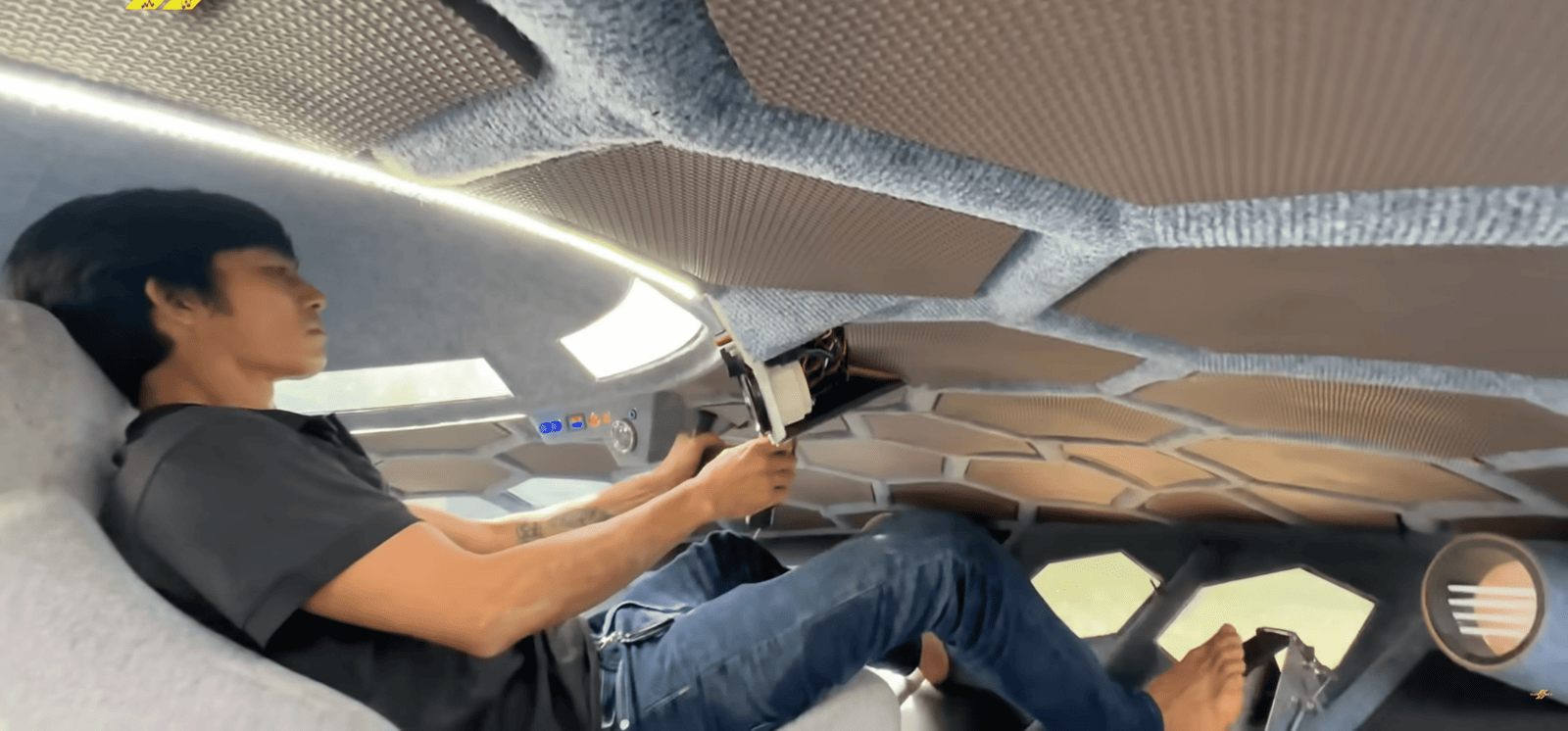 a man driving a homemade flying saucer while lying down