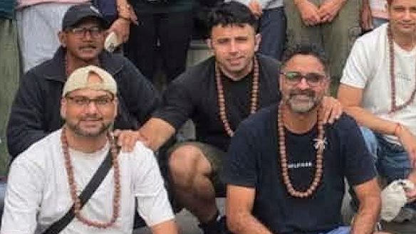 Missing Brisbane father Karan Bhardwaj holds the shoulders of his friends, Arpan Mithalal Kothari (left) and Bhavinkumar Rajnikant Raval shortly before departing with the Kailash Journeys tour group. 