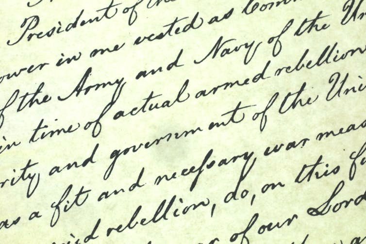 Cursive writing is seen covering a yellow piece of paper.