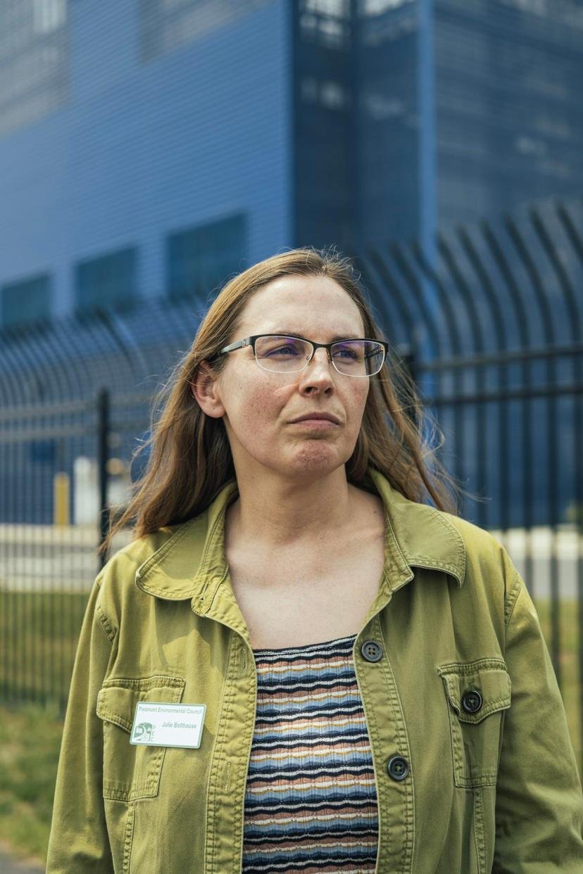 Piedmont Environmental Council land use director Julie Bolthouse stands in front of the blue Vantage VA2 data center in Ashburn, Virginia.