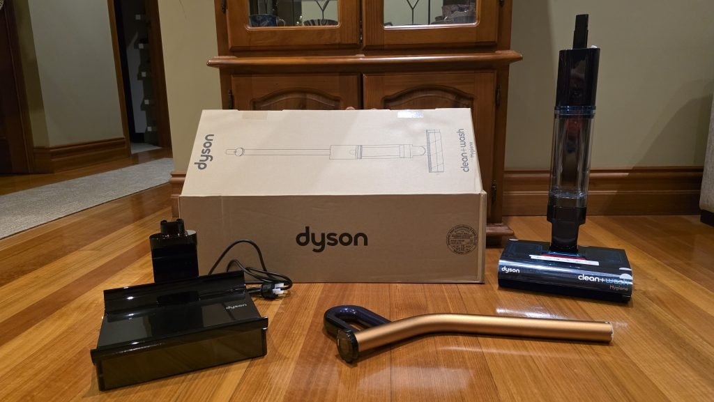Unboxing showing the handle, cleaner part, and charging cradle.