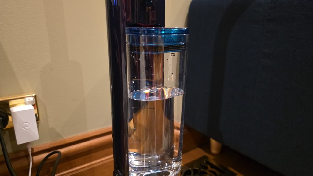 Close up of the caddy with fresh water in it. There's a red button on top that releases the caddy.