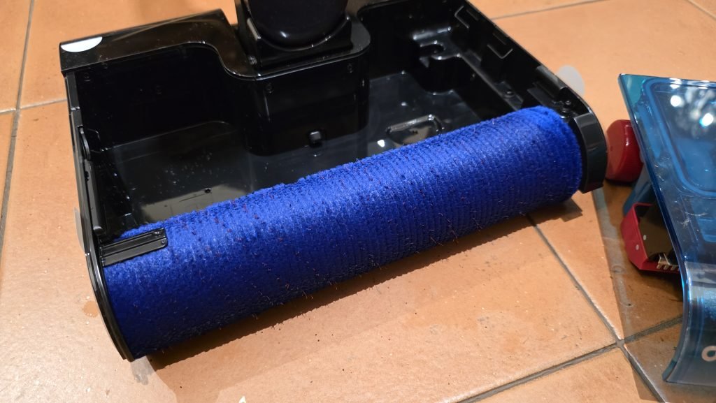 Photo of the roller. The roller is blue and you can clearly see the red bristles sticking out.