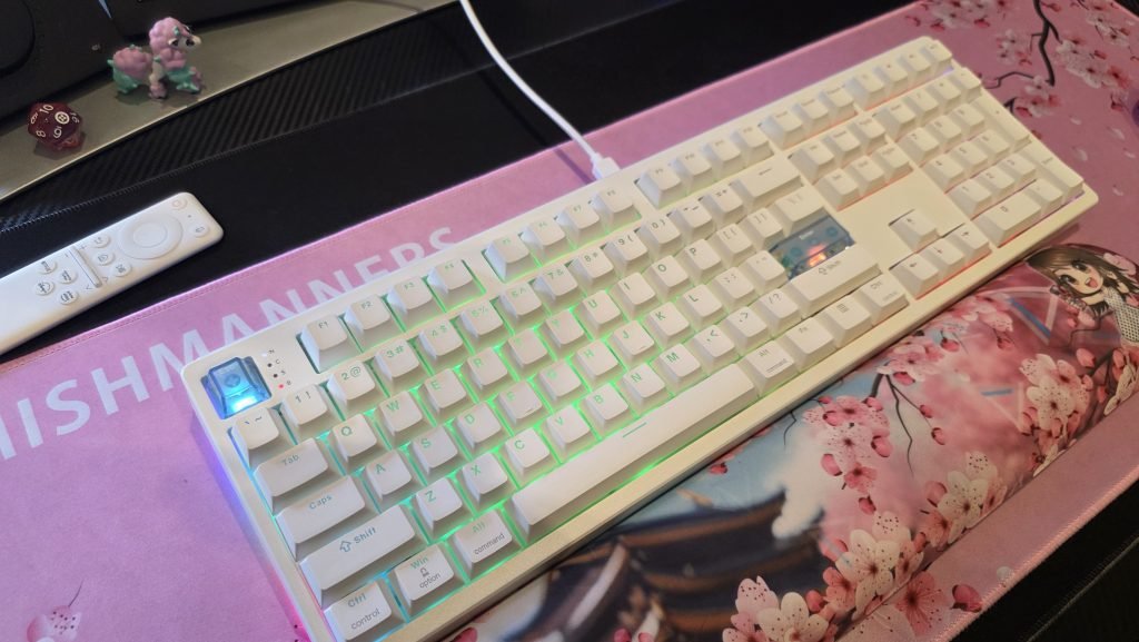 Full length shot of the Epomaker HE108 keyboard showing the original white keys and a soft glow coming through the features on the keycaps.