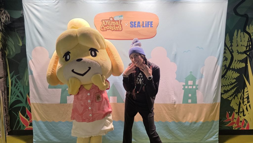 Meet and greet Isabelle. Me standing next to someone dressed up as Isabelle from Animal Crossing.