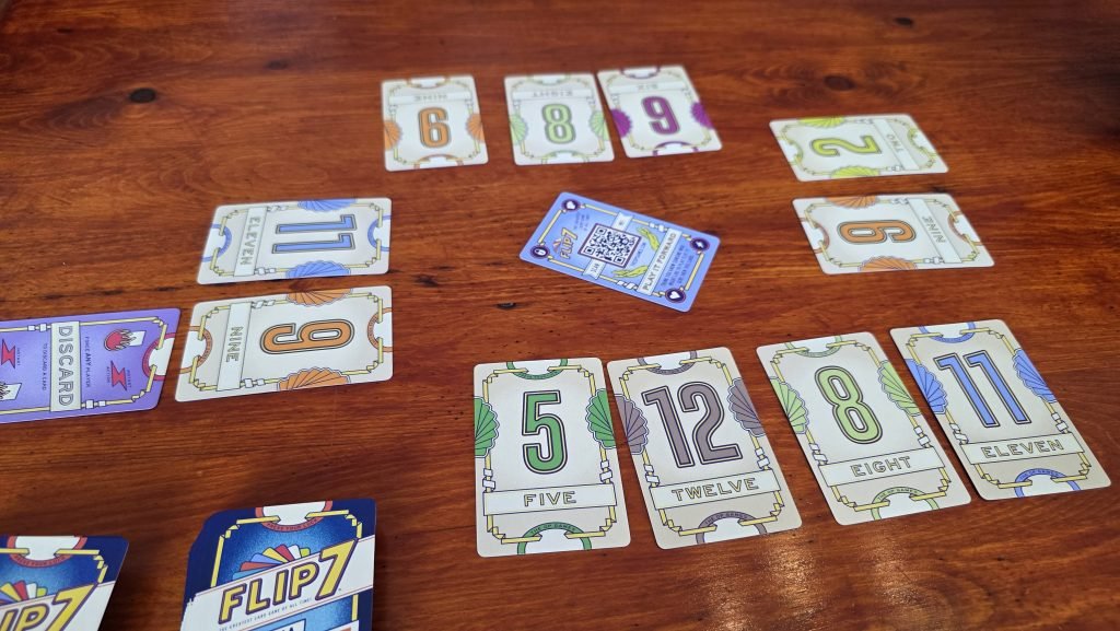 Flip 7 with a Vengeance with four players. One player has drawn the discard card.