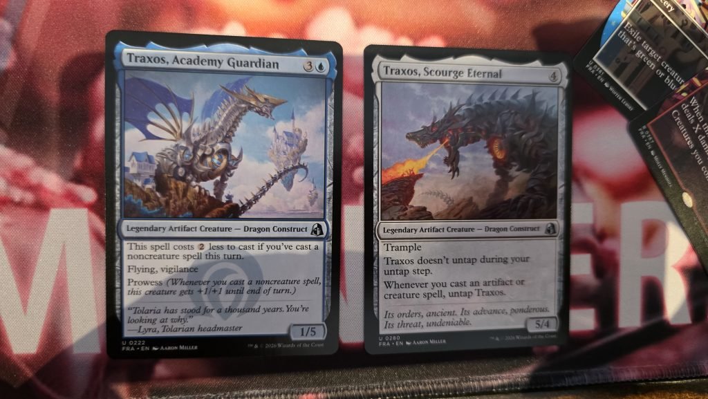 The left shows Traxos, Academy Guardian who is a blue legendary artifact creature card, and then Traxos, Scourge Eternal a neutral legendary artifact card. They have different abilities. 
