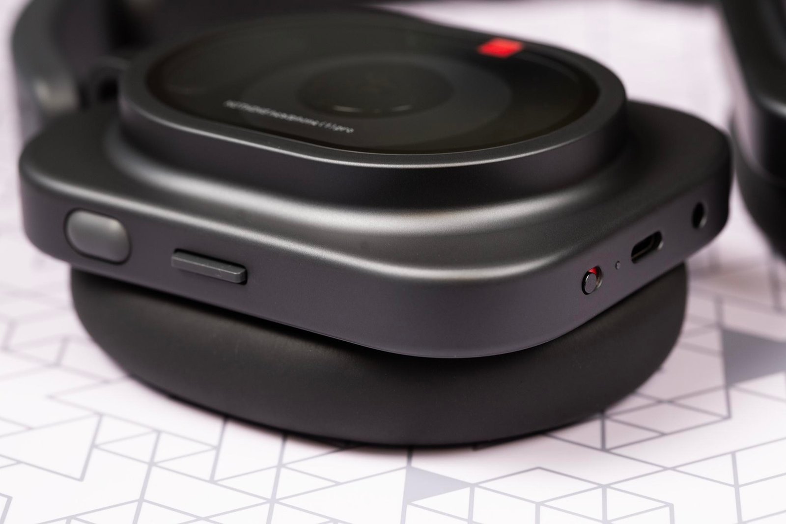 Macro shot of button and ports on a pair of Nothing Pro 1 headphones.