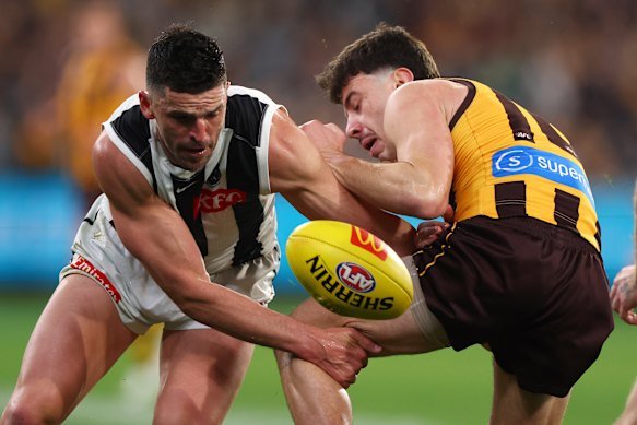 Scott Pendlebury of the Magpies and Massimo D’Ambrosio of the Hawks contest the ball.