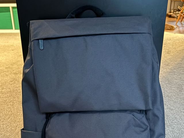 Front view of Everlane ReNew Transit Backpack, a grey bag with black straps and simple zipper pouch