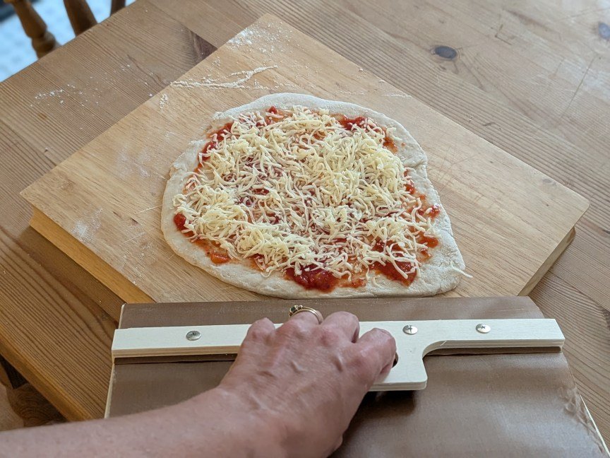 pizza peel lifting uncooked pizza