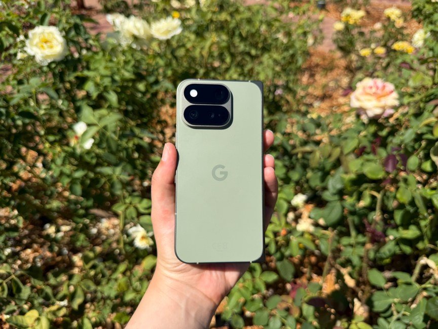 The Pixel 11 Pro Fold in olive, amid rose bushes